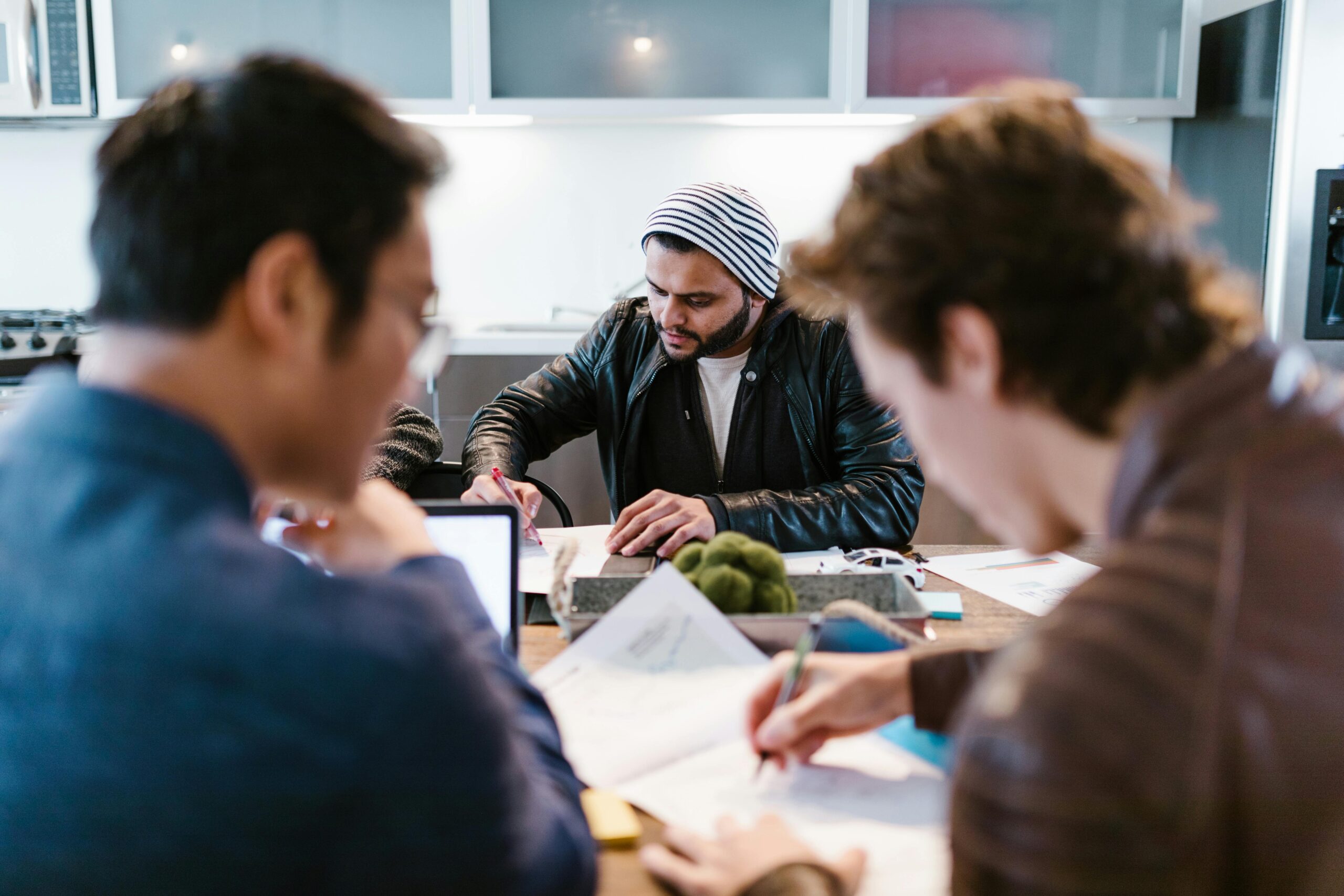 Diverse group of coworkers engaging in a brainstorming session in a modern office.